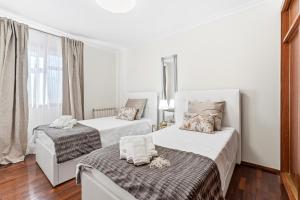a white room with two beds and a window at Vale do Vez in Arcos de Valdevez