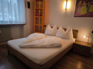a bedroom with a bed with white sheets and pillows at Klaus Luttach in Lutago