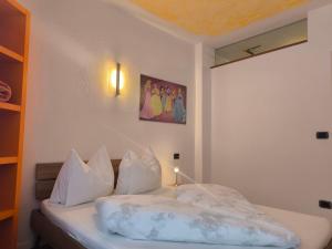 a bed with white pillows and a picture on the wall at Klaus Luttach in Lutago