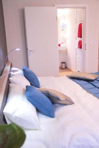a bedroom with blue pillows on a white bed at BB Blick Hotel und Café in Bad Bellingen +1 photo