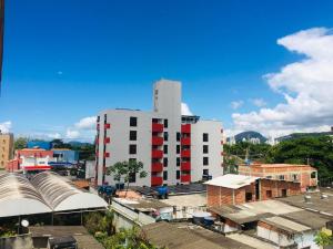 a white and red building in a city with buildings at Edifício Nautilus in Guarujá