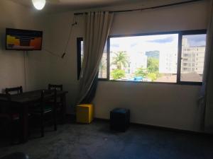a room with a table and a large window at Edifício Nautilus in Guarujá
