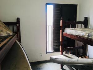 a room with two bunk beds and a window at Edifício Nautilus in Guarujá