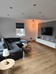 a living room with a black couch and a fireplace at Ferienwohnungen Recklinghausen-Nord in Recklinghausen