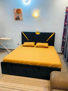 a bedroom with a bed with a yellow bedspread at Résidence GOUDJA 2 in Cotonou