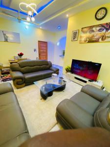 a living room with couches and a flat screen tv at Résidence GOUDJA 2 in Cotonou