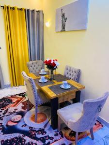 a dining room with a wooden table and chairs at Résidence GOUDJA 2 in Cotonou