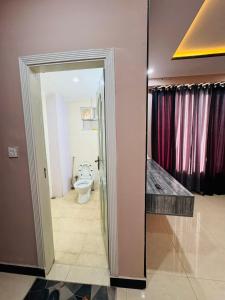 a bathroom with a toilet and a mirror at Stay Homie - 1BHK, Near ISB Airport, Self Check-In, Secure in Islamabad +10 photos