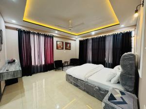 a bedroom with a bed with a chair in it at Stay Homie - 1BHK, Near ISB Airport, Self Check-In, Secure in Islamabad