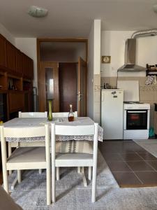 a kitchen with a white table and a white refrigerator at Lana in Trebinje +3 photos