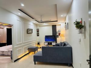 a living room with a couch and a tv at Stay Homie - 1BHK, Near ISB Airport, Self Check-In, Secure in Islamabad