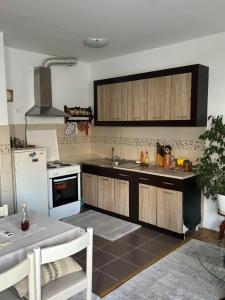 a kitchen with wooden cabinets and a white refrigerator at Lana in Trebinje