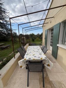 a patio with a table and chairs on a balcony at le mas au pied du Ventoux in Carpentras