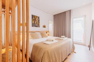 a hotel room with two beds and a window at Laranjal Rive Gauche in Tavira