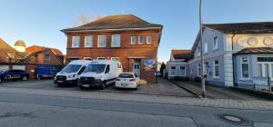 two white vans parked in front of a brick building at Zafibo Gästehaus in Quickborn