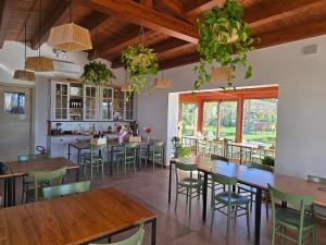a restaurant with wooden tables and chairs and plants at Agriturismo Essentia dimora rurale in Larino