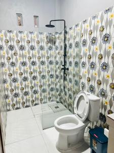 a bathroom with a toilet and a shower curtain at Mama Homestay in Kuta Lombok