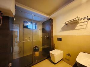 a bathroom with a glass shower and a toilet at mayur Mora in Rāmgarh