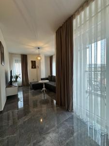 a living room with a couch and a large window at Star apartmani in Novi Pazar
