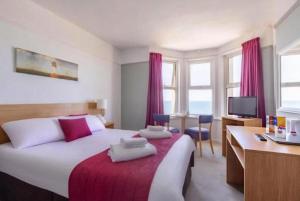a bedroom with a bed and a desk with a computer at The Beresford Hotel in Newquay