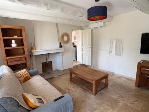 a living room with a couch and a table at le mas au pied du Ventoux in Carpentras