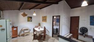 a kitchen with a table and a room with a bed at Porto do Sol - Chalé 07 in Pipa