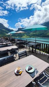 a wooden table with a cup of coffee on top of a deck at Chalet de Roselend in Beaufort +52 photos