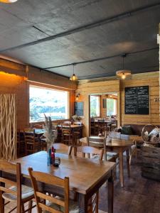 a restaurant with wooden tables and chairs and a chalkboard at Chalet de Roselend in Beaufort