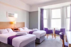 a hotel room with two beds and a couch at The Beresford Hotel in Newquay