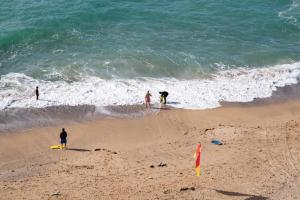 a group of people standing on a beach near the ocean at The Beresford Hotel in Newquay