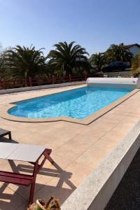 a large swimming pool with a table and a bench at L'Estel in Hasparren