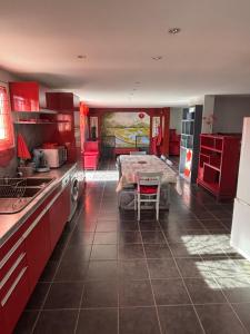 a kitchen with red cabinets and a table in it at L'Estel in Hasparren +2 photos