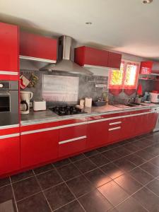 a kitchen with red cabinets and a stove top oven at L'Estel in Hasparren