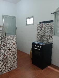 a kitchen with a stove and a wall with tiles at Refúgio da Aldeia - trabalho ou lazer! in São Pedro da Aldeia +15 photos