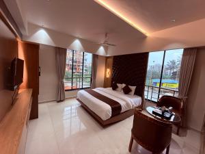 a hotel room with a bed and a tv and windows at Hotel Classic Badlapur - Premium Couple Friendly Hotels in Badlapur in Badlapur +54 photos