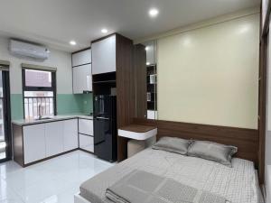 a bedroom with a bed and a black refrigerator at Trang Due homestay in An Dương