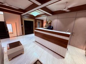 a man standing behind a counter in a lobby at Hotel Classic Badlapur - Premium Couple Friendly Hotels in Badlapur in Badlapur
