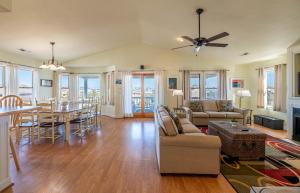 a living room with a table and a dining room at Funtiki - S Nags Head MP 17.5, Semi-Oceanfront, 150 Yds to Beach, Pool, Hot Tub, Pool Table, Pets OK in Whalebone