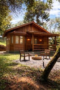 a log cabin with a fire pit in front of it at Cabanas Green Valley in Monte Verde