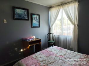 a bedroom with a bed and a dresser and a window at Casa Amoblada para Empresas in Los Ángeles
