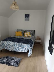 a bedroom with a bed with yellow pillows on it at Les mouettes in Huisnes-sur-Mer