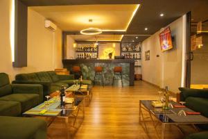 a living room with green couches and a bar at Résidence PLAZZAET OUAGA 2000 in Ouagadougou