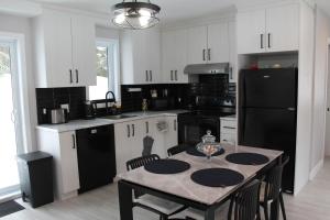 a kitchen with a table and a black refrigerator at La Casa TiMoris in Wentworth-Nord