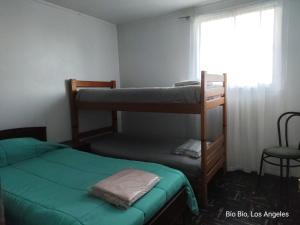 a bedroom with two bunk beds and a window at Casa Amoblada para Empresas in Los Ángeles +2 photos