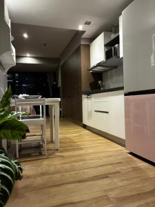 a kitchen with white cabinets and a table and a floor at Loft Vista Revolución in Mexico City