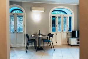 a dining room with a table and chairs and windows at BELLAGIO SUN pool near lake free parking in Bellagio