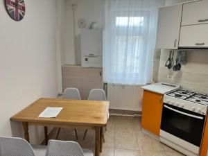 a kitchen with a table and a stove and a table and chairs at Apartament Amalia in Roman