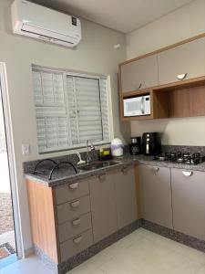 a kitchen with a sink and a microwave at Studio J&C in Primavera do Leste