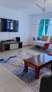a living room with a coffee table and a couch at Palm Comfort Apartment in Bamburi