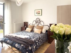 a bedroom with a bed and a vase of flowers at Intera casa con due appartamenti indipendenti e vasca idromassaggio a Barbaresco, Langhe in Barbaresco